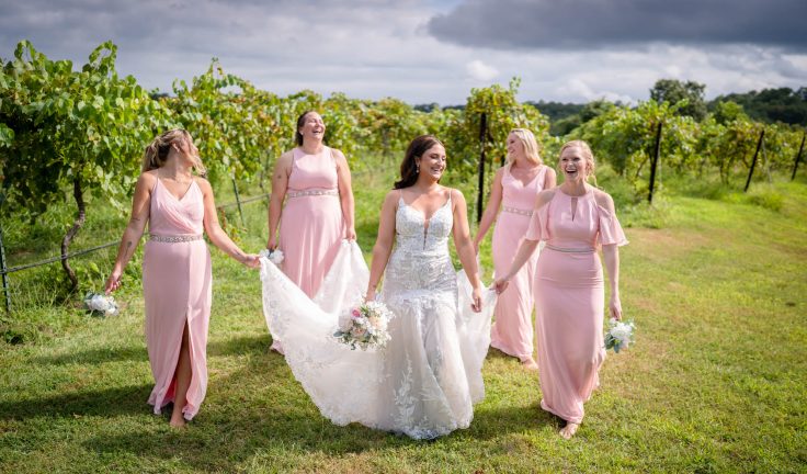 bride and bridesmaids walking together wedding photo by lake of the Ozarks wedding photographer Mitchell Bennett Photography