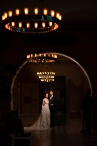 bride and groom under a row of chandeliers in St Louis Union Station
