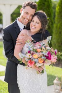 bride and groom hugging with bright florals