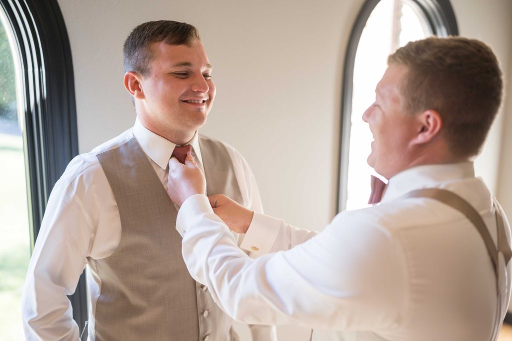 groom getting tie by Lake of the Ozarks Wedding Photographer Mitchell Bennett Photography