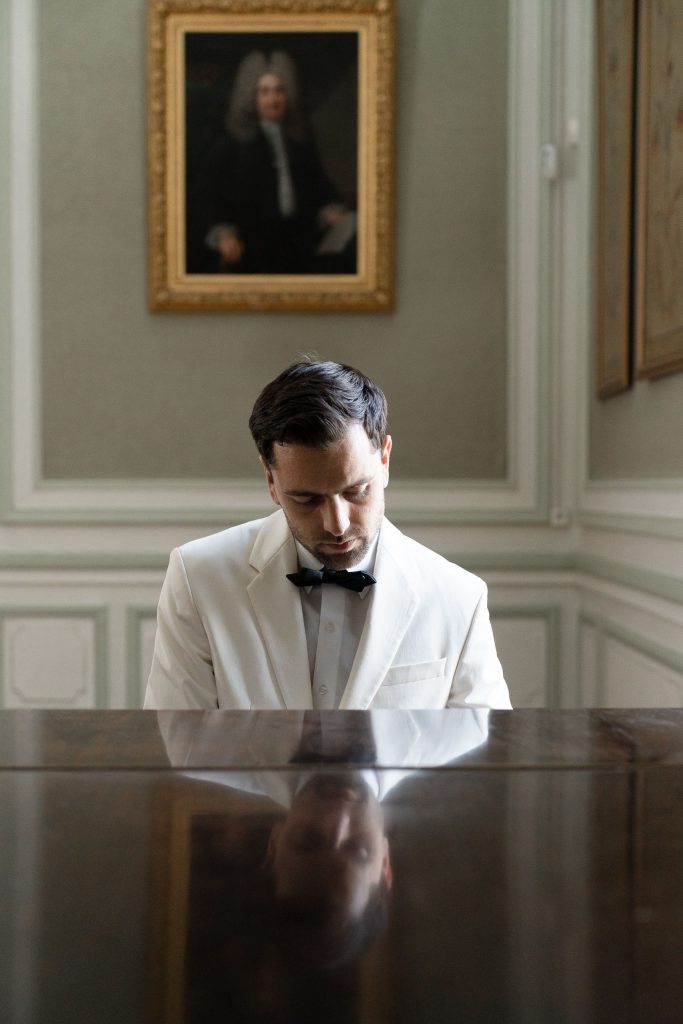 groom playing piano by Lake of the Ozarks Wedding Photographer Mitchell Bennett Photography