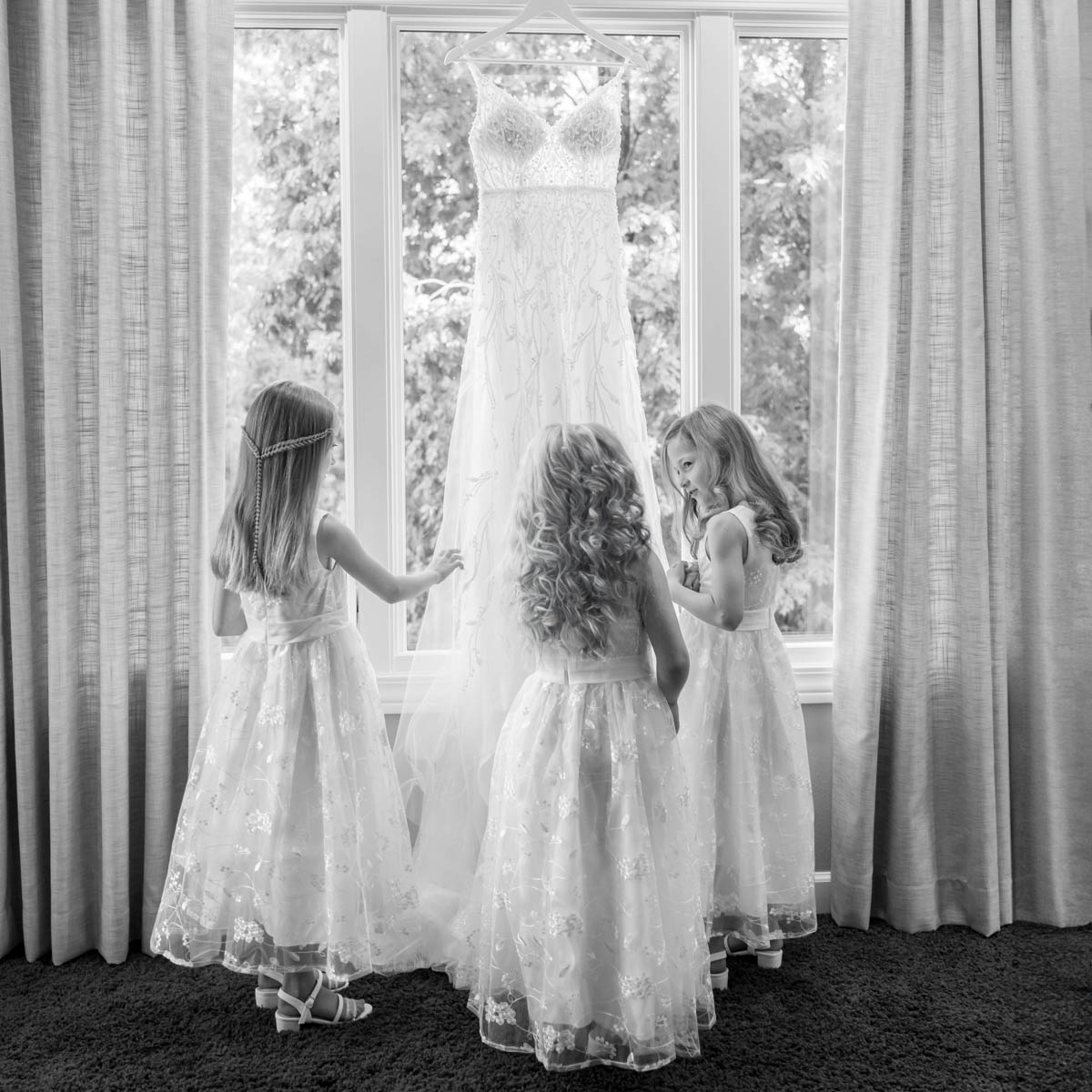 Flowergirls looking at a wedding dress by St. Louis Photographer Mitchell Bennett Photography